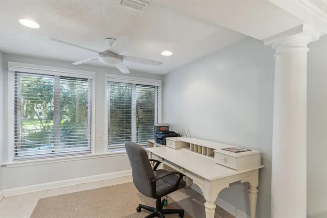 a view of a workspace with furniture and a window