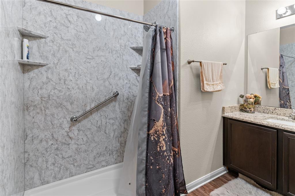 3005 Parker Road Anna, TX 75409 - Photo 7 of 17 Shower-tub combination featuring a textured, light-toned surround with integrated shelving and a grab bar