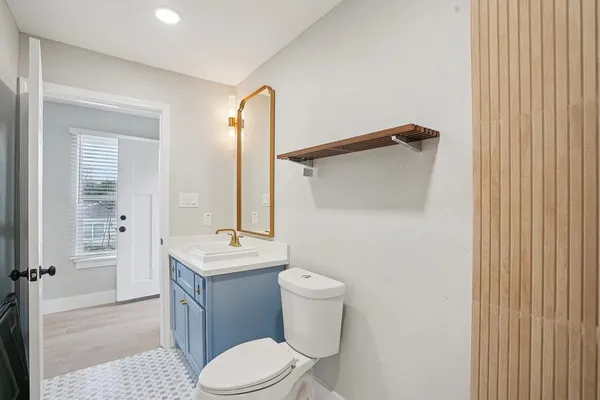 a bathroom with a sink a toilet a mirror and vanity
