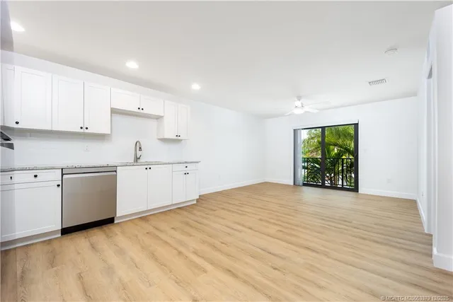 a view of a kitchen with wooden floor and electronic appliances