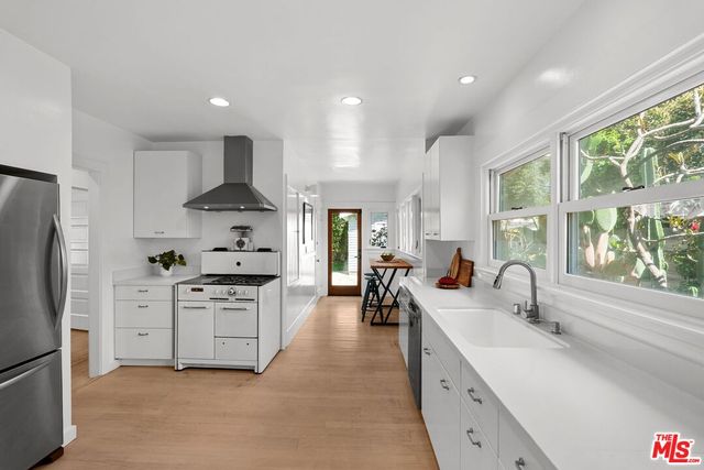 a kitchen with stainless steel appliances a sink stove and refrigerator