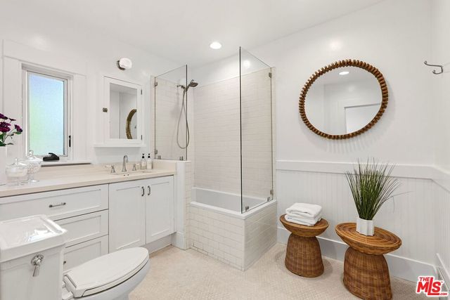 a bathroom with a toilet a sink a mirror and vanity