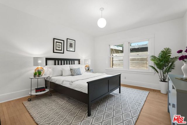 a spacious bedroom with a bed and a potted plant
