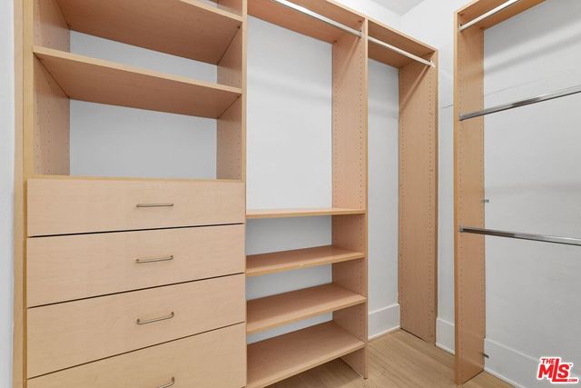 a view of walk in closet with empty racks