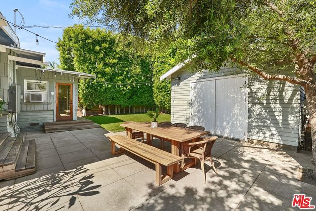 a view of backyard with a table and chairs next to a yard