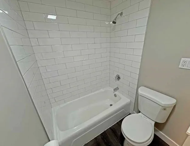 a white toilet and tub next to a bathroom sink