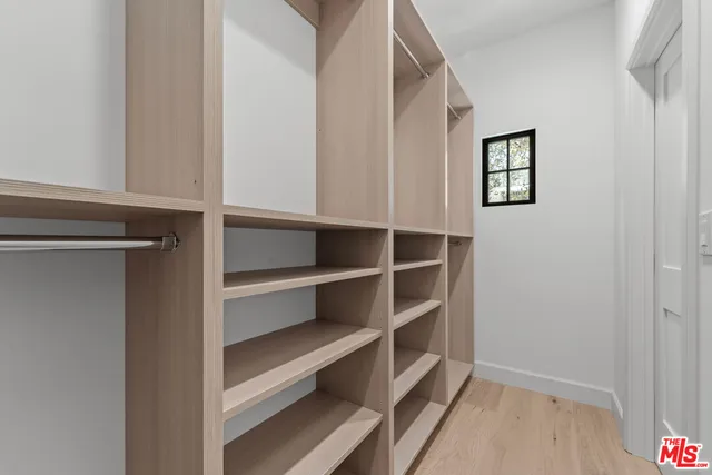 a view of walk in closet with empty racks