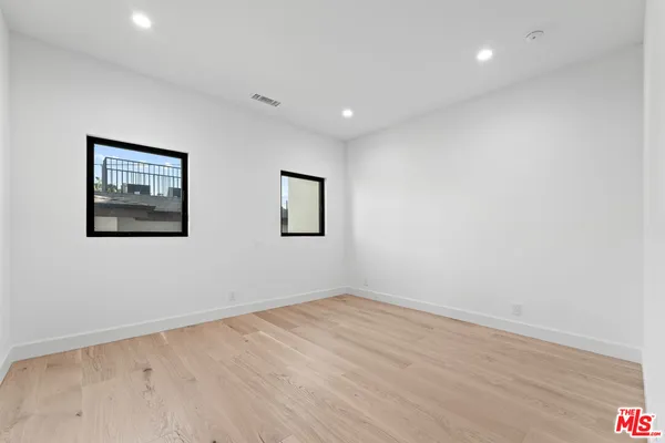 a view of empty room with wooden floor