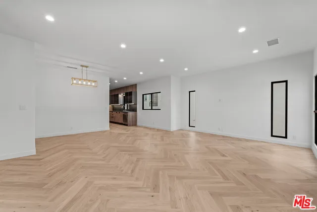 a view of an empty room with closet and a window