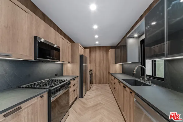 a kitchen with stainless steel appliances granite countertop a stove a sink and a refrigerator