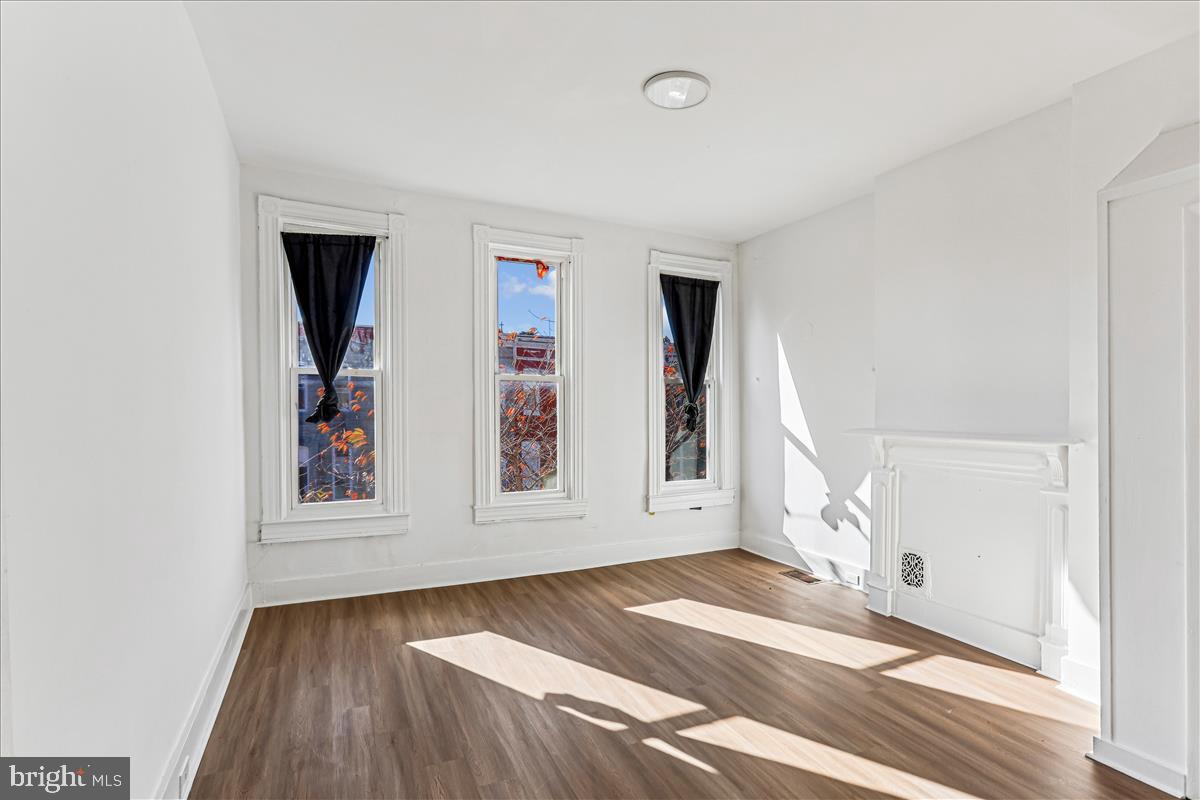 2023 Division Street Baltimore, MD 21217 - Photo 19 of 35 a view of an empty room with wooden floor and a window