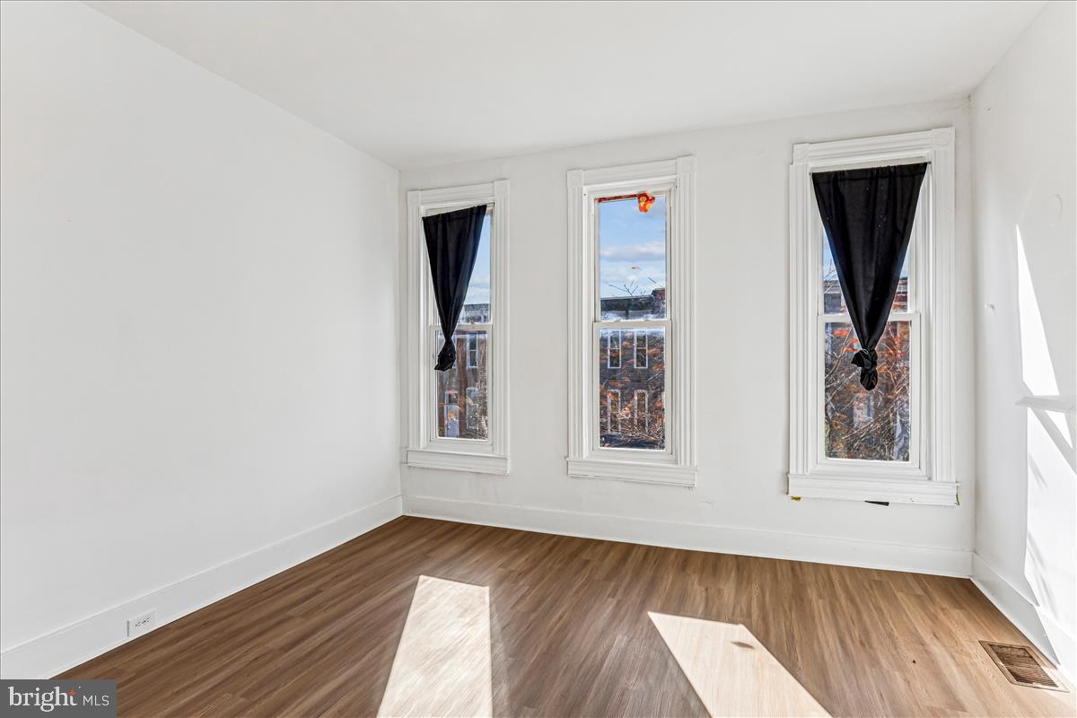 2023 Division Street Baltimore, MD 21217 - Photo 20 of 35 an empty room with wooden floor and window