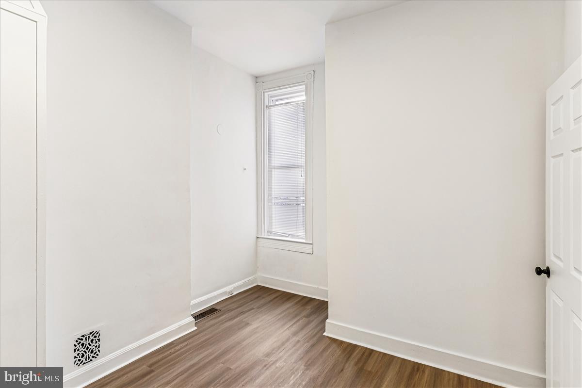2023 Division Street Baltimore, MD 21217 - Photo 23 of 35 a view of an empty room with wooden floor and a window