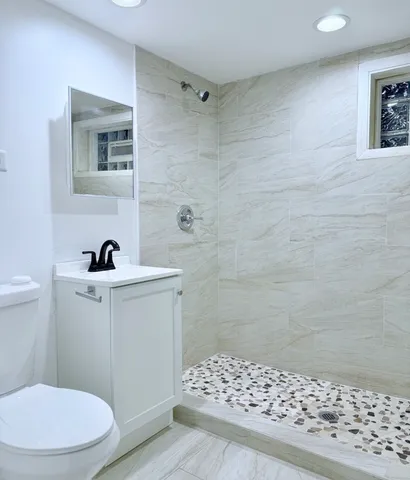 a bathroom with a sink a toilet a shower and a mirror