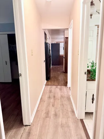 a view of a hallway with wooden floor and staircase