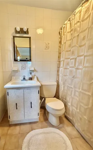 a bathroom with a sink toilet mirror and shower
