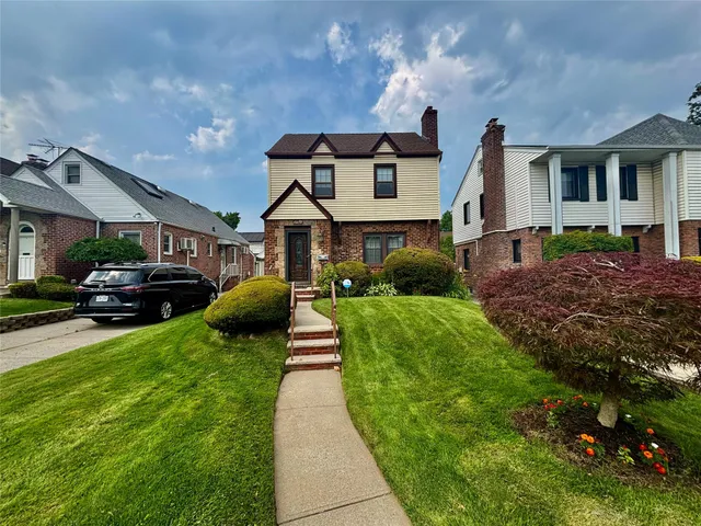 a front view of a house with a yard and potted plants