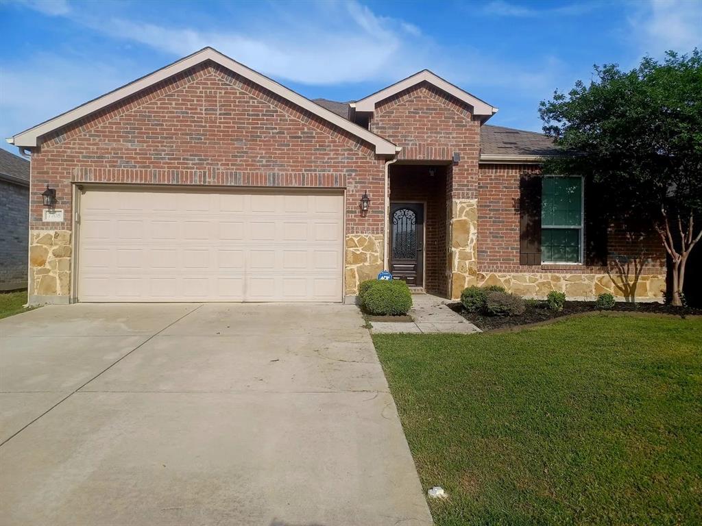 Single story home featuring stone siding, concrete driveway, a front lawn, and a garage
