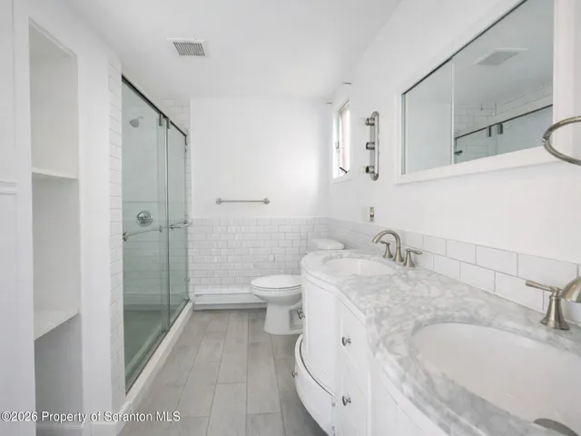 a bathroom with a granite countertop sink toilet and shower