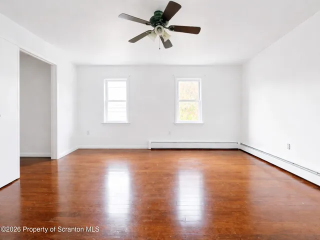 a view of a room with wooden floor and a window