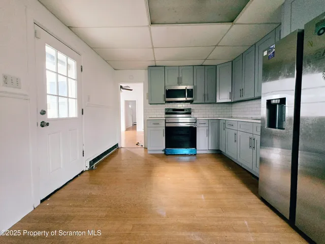 a kitchen with stainless steel appliances granite countertop a refrigerator a stove and a sink