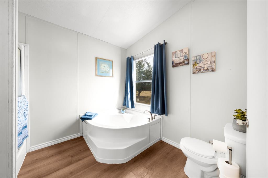 366 Tony Lane Fate, TX 75189 - Photo 20 of 36 a bathroom with a white tub sink and a toilet