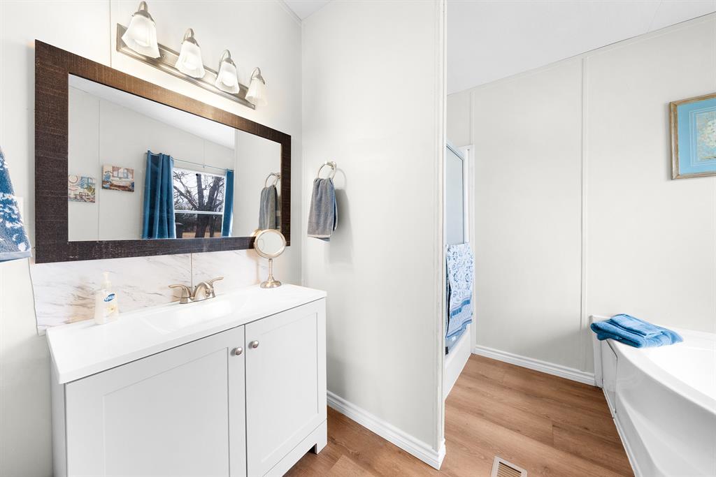 366 Tony Lane Fate, TX 75189 - Photo 21 of 36 a bathroom with a sink a vanity and a mirror