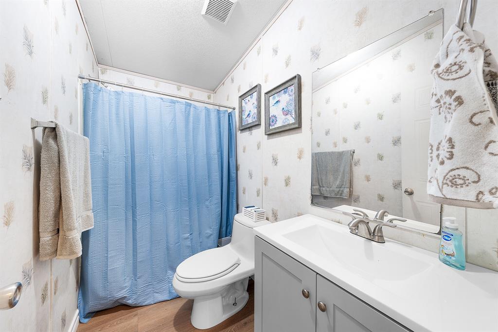 366 Tony Lane Fate, TX 75189 - Photo 25 of 36 a bathroom with a sink a toilet and shower curtain