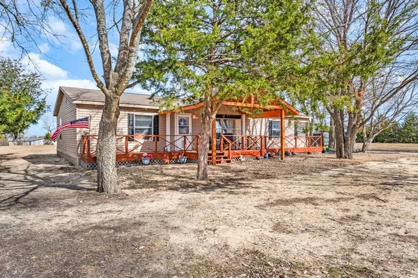 a front view of a house with a tree