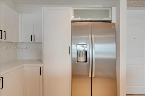 a kitchen with white cabinets and wooden floor