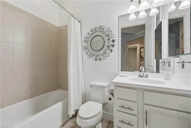 a bathroom with a granite countertop sink mirror toilet and bathtub