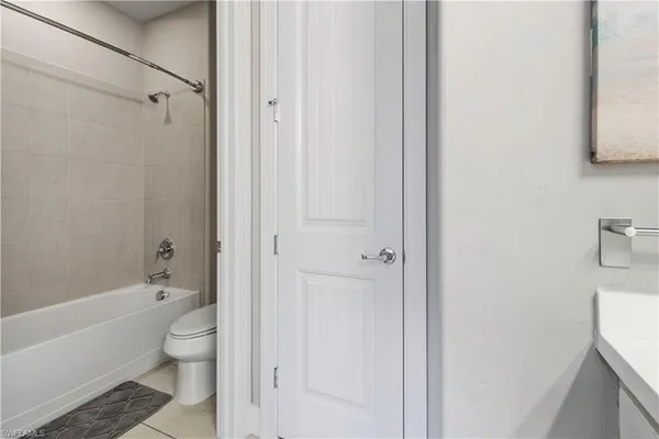 a bathroom with a granite countertop bathtub shower and toilet