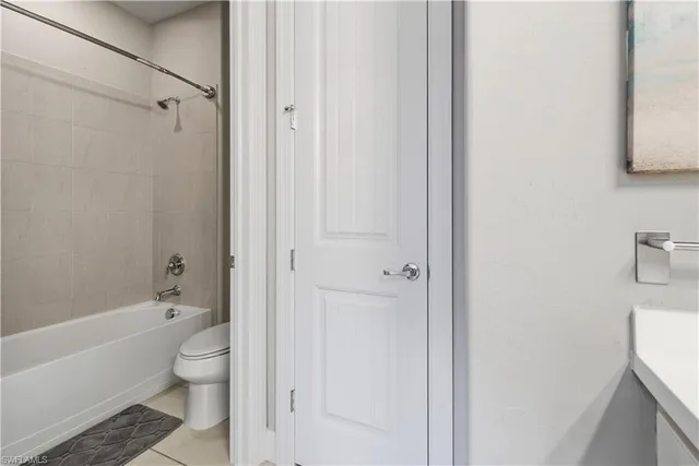 a bathroom with a granite countertop bathtub shower and toilet