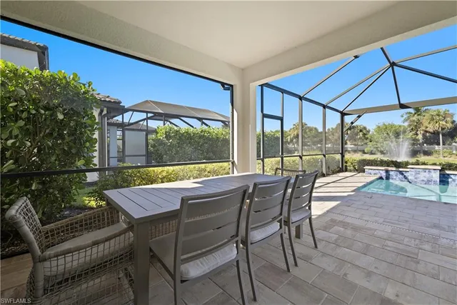 a patio with lawn chairs and umbrella
