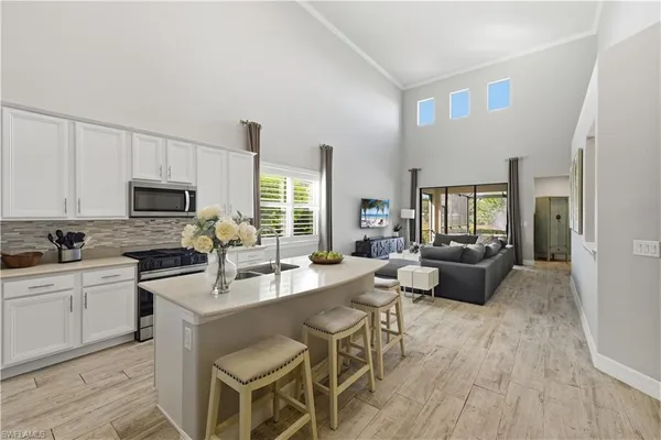 a large kitchen with a table chairs wooden floor and stainless steel appliances