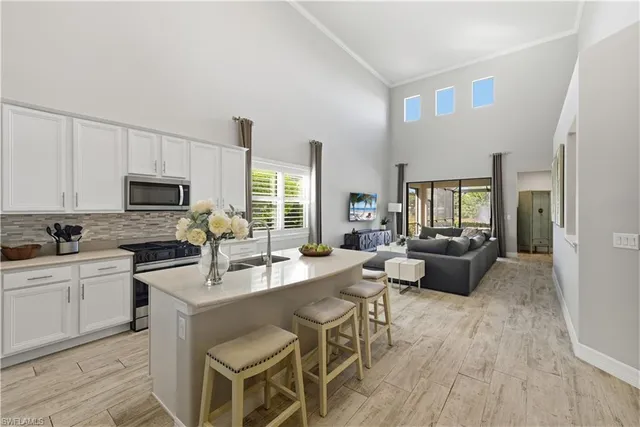a large kitchen with a table chairs wooden floor and stainless steel appliances