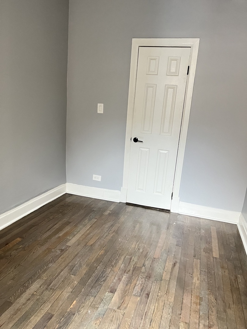 3821 West Fillmore Street, Unit 1R Chicago, IL 60624 - Photo 12 of 14 a view of an empty room with wooden floor