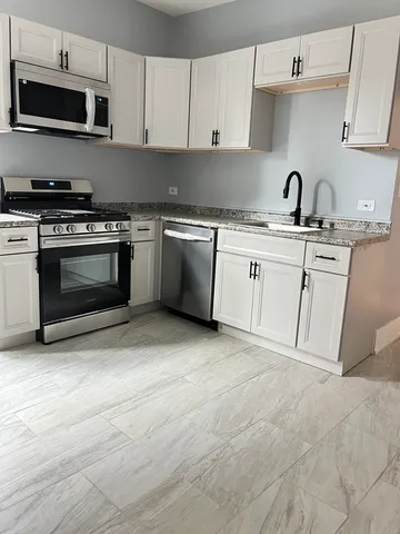 a kitchen with appliances a sink and cabinets