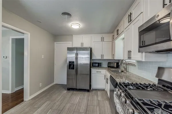 a kitchen with stainless steel appliances a stove a sink and a refrigerator