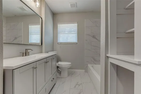 a bathroom with a sink toilet and window