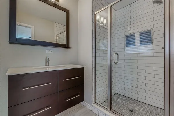 a bathroom with a sink a mirror and shower
