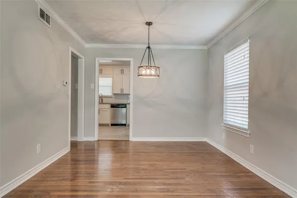 a view of a room with wooden floor windows and a chandelier