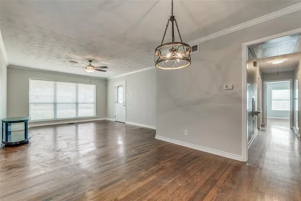 a view of empty room with wooden floor and window
