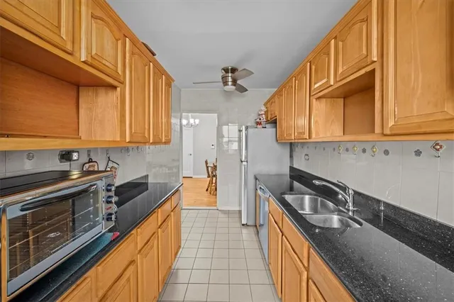 a kitchen with stainless steel appliances granite countertop a sink a stove and cabinets