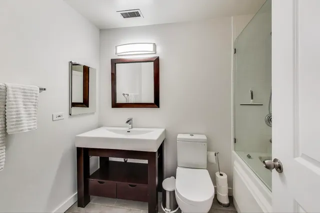 a bathroom with a toilet a sink and mirror