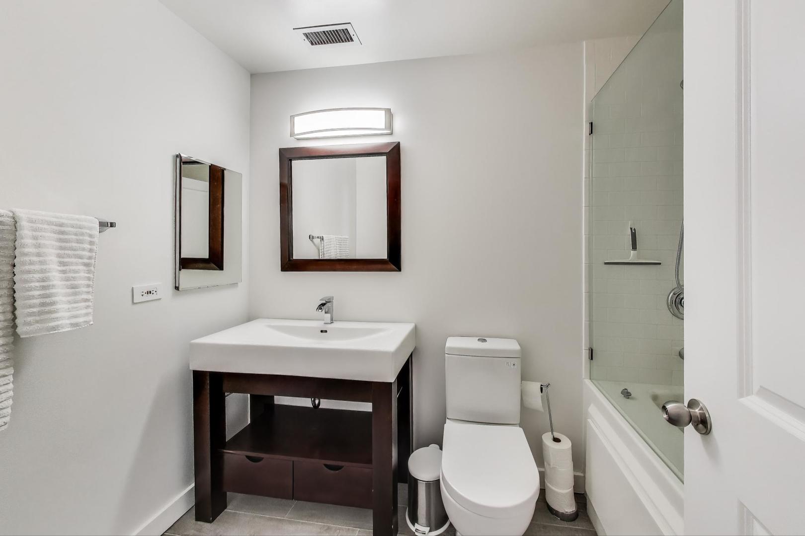 1301 West Madison Street, Unit 311 Chicago, IL 60607 - Photo 14 of 21 a bathroom with a toilet a sink and mirror