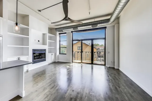 a view of an empty room with a fireplace and a window