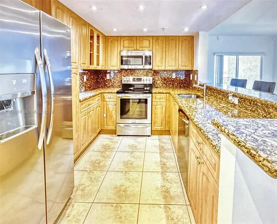 a kitchen with stainless steel appliances granite countertop a stove a sink and a refrigerator