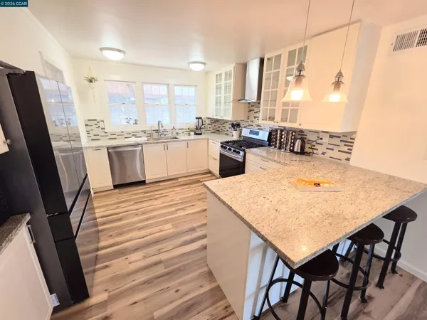 a kitchen with stainless steel appliances granite countertop a stove a sink and a microwave