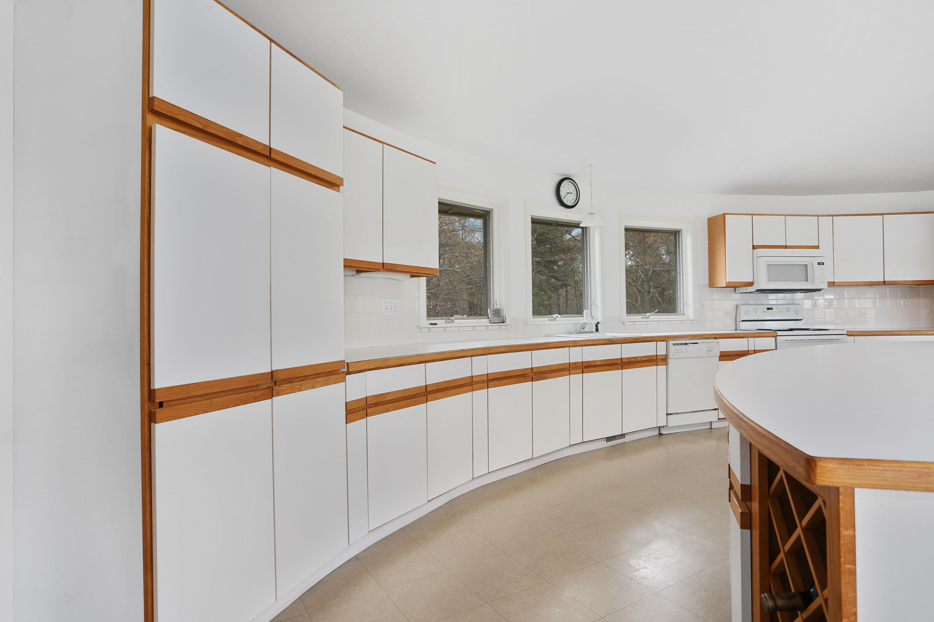 38 Weather Deck Road Bourne, MA 02532 - Photo 22 of 40 a large white kitchen with wide window and sink